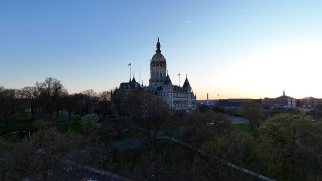 Drone video rising up for aerial view of the Connecticut State Capitol building perched atop its hill overlooking Bushnell Park and downtown Hartford at dusk