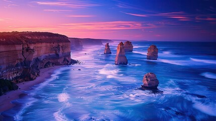 The image shows a beautiful sunset over the Twelve Apostles, a series of limestone stacks off the coast of Victoria, Australia. The sky is a vibrant mix of oranges, pinks, and purples, and the water i - obrazy, fototapety, plakaty