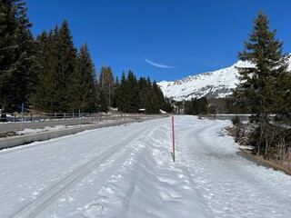 A winter sport cross-country ski trail around a frozen alpine Heidsee lake (Igl Lai lake) in the Swiss winter resorts of Valbella and Lenzerheide - Canton of Grisons, Switzerland (Schweiz)