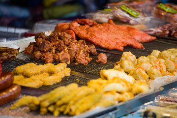 a variety of delicious fried foods displayed in metallic bowls at a street food stall