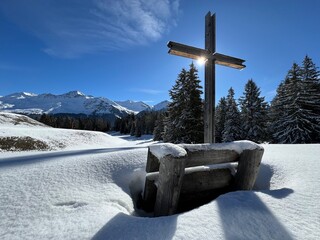 Christian crucifix in the magical winter setting of the Swiss Alps and on the snow-covered alpine...