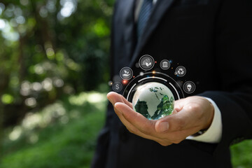 Businessman hand holding crystal globe with green business icons, Ecosystem and organization development cooperation.