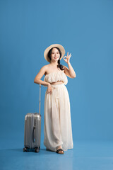 Portrait of asian girl posing on blue background, traveling in summer