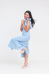 Joyful young Asian woman in powder blue dress celebrates good news