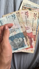 Hand holding some colombian Pesos banknotes - obrazy, fototapety, plakaty