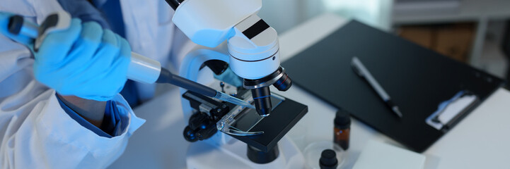 Scientist working in laboratory using micropipette Mixing liquid chemicals with genetically modified samples under a biotechnology microscope. Development of microbiology research experiment.