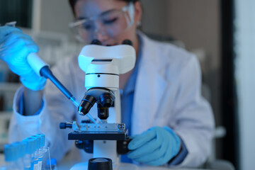 Scientist working in laboratory using micropipette Mixing liquid chemicals with genetically modified samples under a biotechnology microscope. Development of microbiology research experiment.