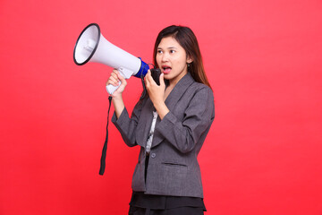 Asian girl manager's expression tilted to the right, screaming in surprise, using a megaphone, holding a candid microphone, wearing a gray jacket and a red skirt. for broadcast and advertising concept