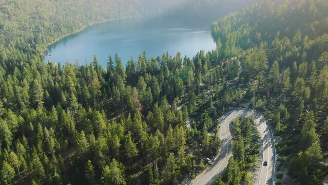 An aerial perspective of a road winding through the dense forest of Lake Tahoe, California, USA. 4K footage. 