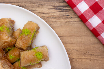Baklava on plate, Turkish Baklava with pistachio on plate,  dessert on white plate with red and white checkered cover,  top view, background.