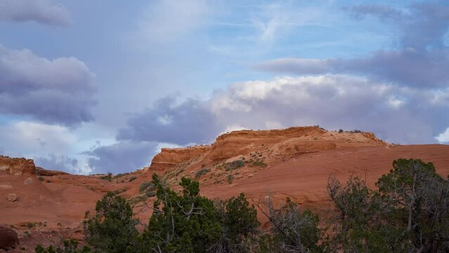 Timelapse of clouds moving over the glowing sandstone in Escalante desert in Utah.