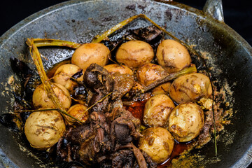 Full frame view of chicken eggs boiled with selected spices isolated in a frying pan.