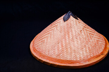 hat with woven bamboo, black background with empty space for advertising.