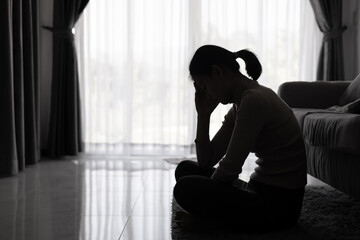Depressed woman, Silhouette of teenager girl with depression sitting alone  in the dark room. Black...