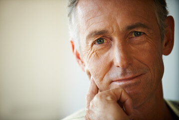 Fototapeta premium Headshot, senior man and portrait thinking about retirement at home, apartment and living room with mockup space. Hand, idea and mature male person in house to relax in lounge for elderly care