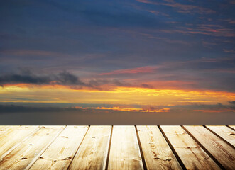 Fototapeta na wymiar Wooden table on sky background and sunset light
