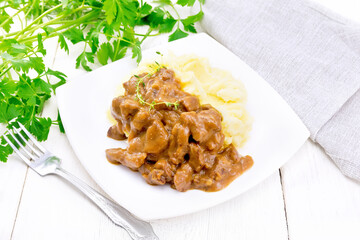 Goulash of beef with mashed potatoes in plate on light board