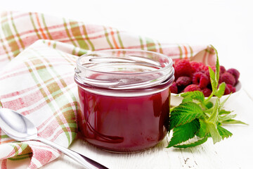 Jam of raspberry in jar on white board