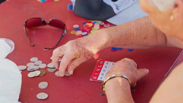 older woman counting coins to play bingo 