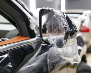 ar wrapping close-up. Car wrapping. A car wrapping specialist applies a polyurethane film to the...