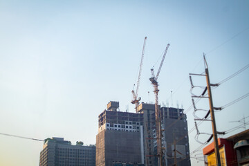 it about the tower crane installed on the building in the city with the electric pole in the foreground
