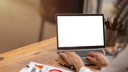 Close-up of a professional's hands typing on a laptop with a white screen, perfect for mockup...