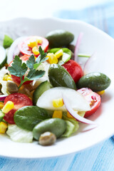 Simple Salad with Green Olives, Cucumber and Cherry Tomatoes. Bright wooden background.	