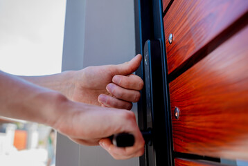 A technician installs a modern smart door lock on the wood door