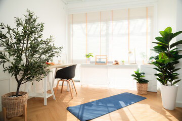 Spacious modern living room with wooden furniture and a glass table near a bright window.yoga at home.