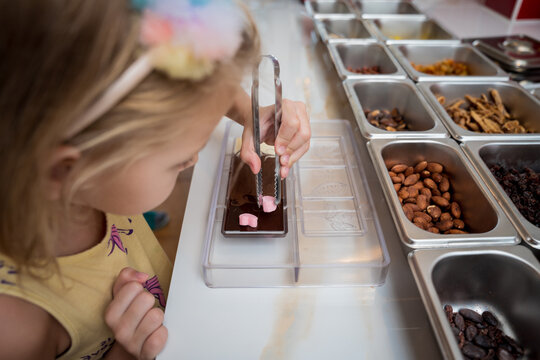Baby girl in the workshop during a lesson on making handmade chocolates and sweets