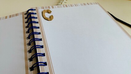 Notebook, diary, paper, pencil, brown, black and white on the table.