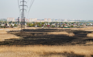 Raging forest fires in spring. Burning dry grass, reeds along the lake. The grass is burning in the...