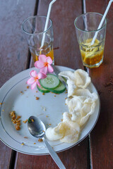Top view of finished fried rice along with drunk iced tea isolated on a wooden table.