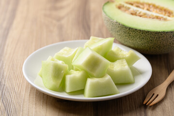 Piece of green melon fruit on plate ready to eating
