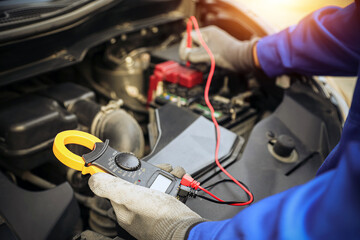 Close-up hand auto mechanic using meter to check car battery fail problem for change repairing and...