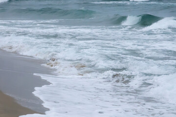 View of the surf on the snowing sand beach