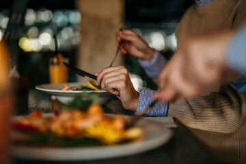 Hand close-up of man eating lunch in a restaurant