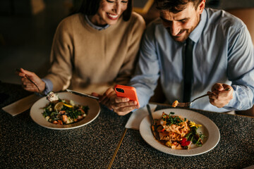 A young couple enjoy eating meals and surfing the net on smartphone