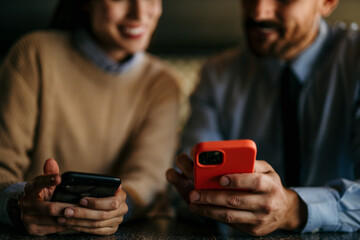 Shot of a young man and woman having a meeting in a cafe and using a phones
