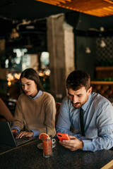 Businessman and businesswoman are having a coffee break together in a cafe