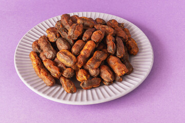 Sweet, spicy tamarind tree fruit on a round plate, close up