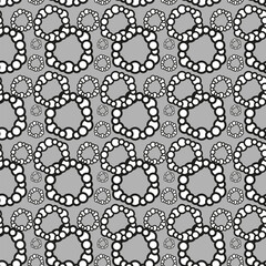 Symmetrical monochrome circles in a seamless pattern on a gray textile backdrop
