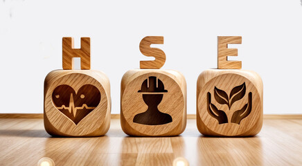 The letters word text abbreviation acronym HSE above three wooden blocks, with symbols on each block representing the different aspects of health, safety, and the environment.
