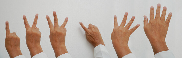 A person holding up one to five fingers on a white background.