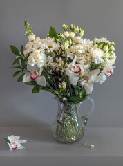 A bouquet of white flowers in a crystal jug.