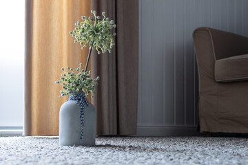 Vase mit Kunstblume auf Teppichboden