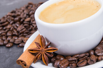 Coffee in cup and roasted dark coffee beans with anise and cinnamon