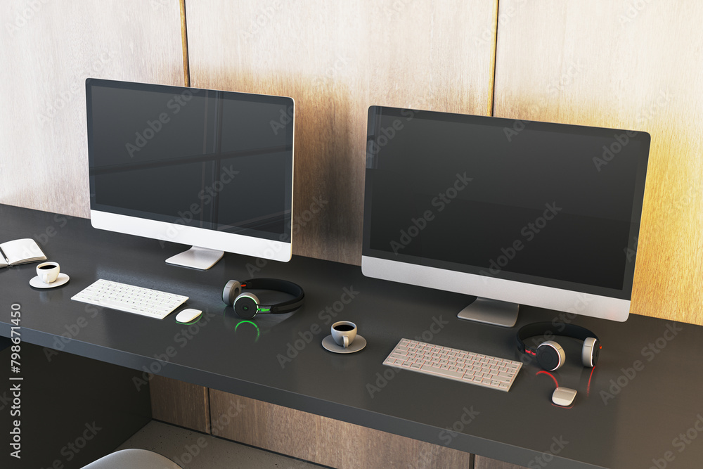 Poster two empty gaming computer monitor on desk with coffee cups and headsets. place for your advertisemen