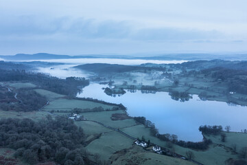 Stunning drone aerial landscape image of cloud inversion around Esthwaite Water in Lake District during Spring sunrise