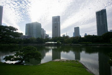 Obraz premium The Gardens of Hamarikyu are a public park in Chūō, Tokyo, Japan. Located at the mouth of the Sumida River they are surrounded by modern buildings.
